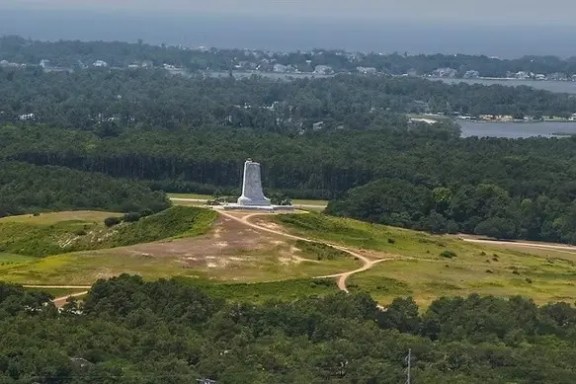 Aerial view of monument surrounded by greenery and winding paths.